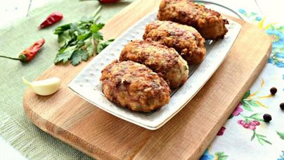 Мясные биточки с рисом и зеленью на сковороде