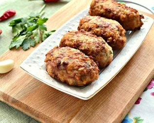 Мясные биточки с рисом и зеленью на сковороде