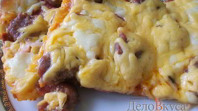 Пицца с домашними колбасками, салями, беконом, моцареллой, твердым сыром и зеленью на тонкой основе