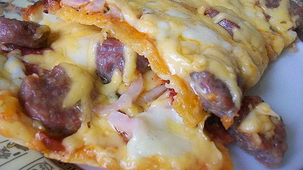 пицца с домашними колбасками, салями, беконом, моцареллой, твердым сыром и зеленью на тонкой основе