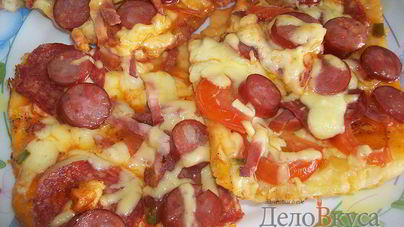 Пицца с салями, колбасой, помидорами, моцареллой, твердым сыром, охотничьими колбасками и зеленью