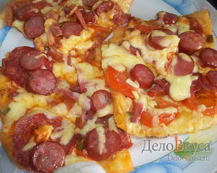 Пицца с салями, колбасой, помидорами, моцареллой, твердым сыром, охотничьими колбасками и зеленью